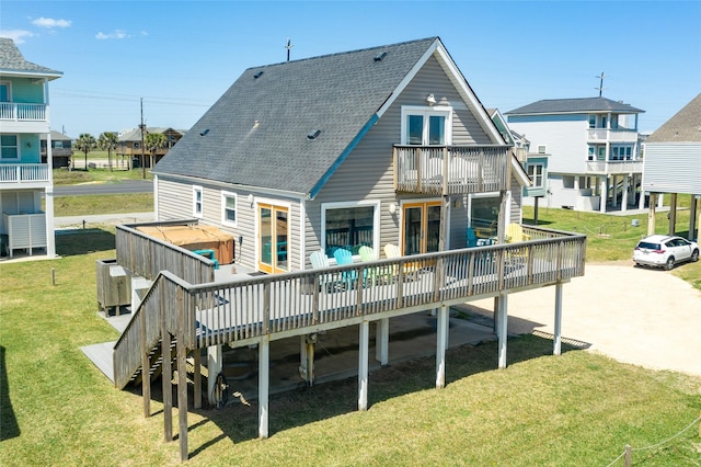 back of property with a lawn, a wooden deck, and french doors