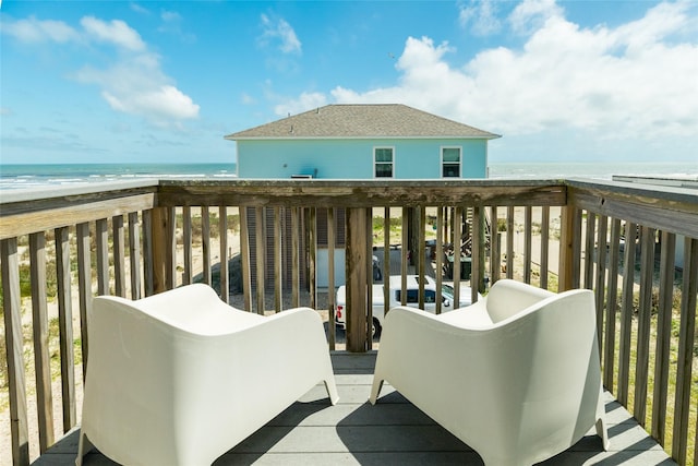 balcony with a water view and a view of the beach