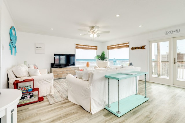 living room with light hardwood / wood-style flooring and ceiling fan