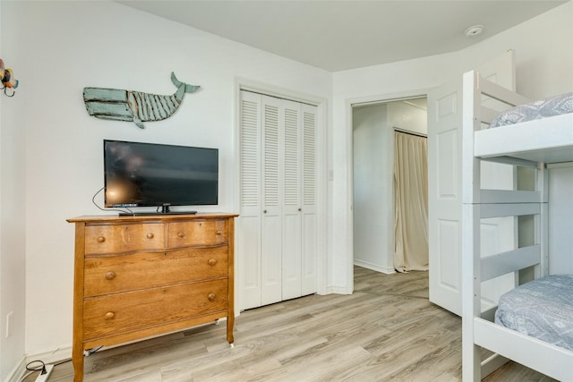 bedroom with a closet and light hardwood / wood-style flooring