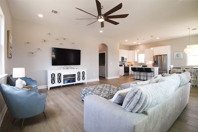 living room featuring light hardwood / wood-style floors and ceiling fan