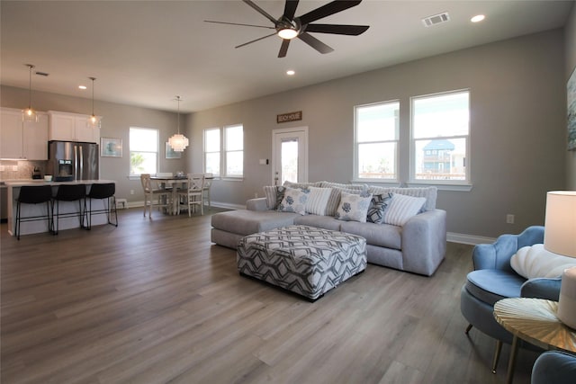 living room featuring light hardwood / wood-style flooring, ceiling fan, and a healthy amount of sunlight