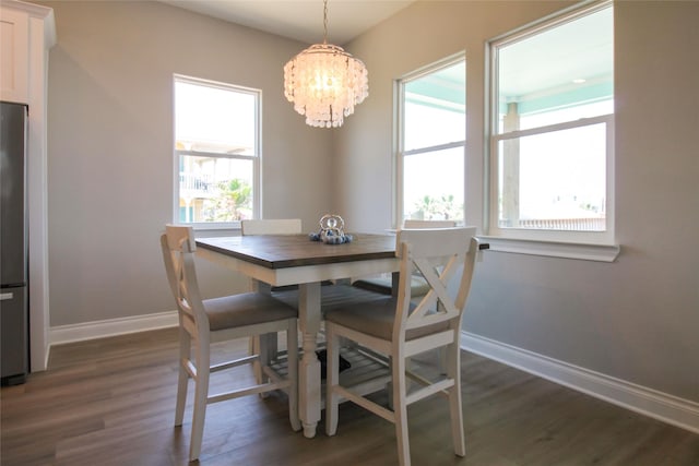 dining space featuring a wealth of natural light, dark hardwood / wood-style flooring, and a chandelier