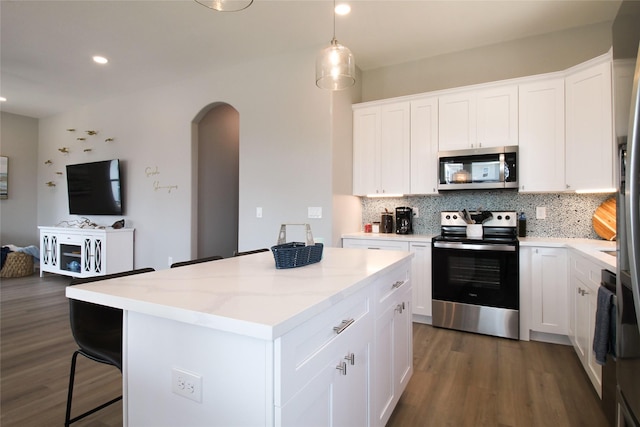 kitchen with backsplash, white cabinets, and appliances with stainless steel finishes