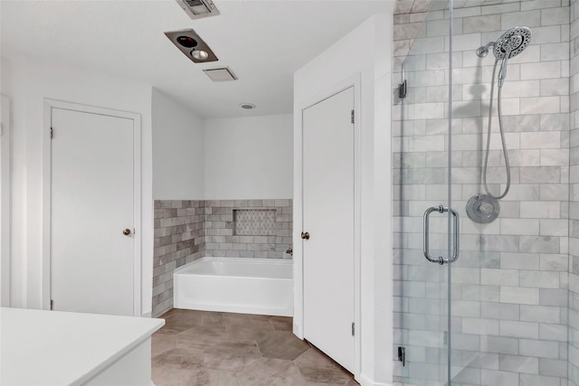 bathroom with a stall shower, visible vents, and a bath