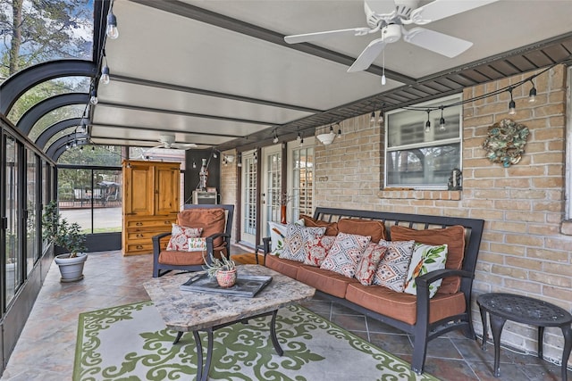 sunroom with a ceiling fan and beamed ceiling