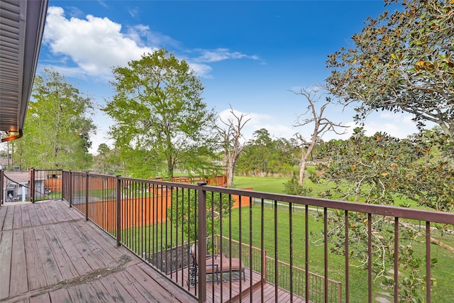 wooden deck featuring a lawn