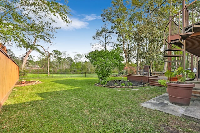 view of yard with a fenced backyard, stairs, and a deck