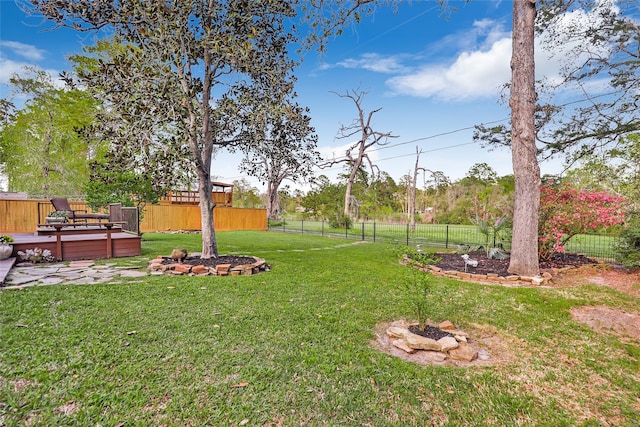 view of yard with fence and a deck