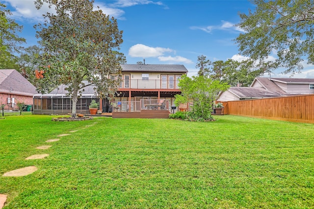 rear view of property featuring a lawn and fence