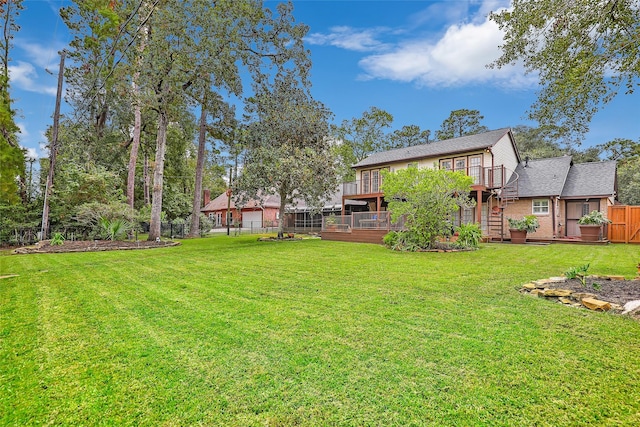 view of yard with a deck, stairway, and fence