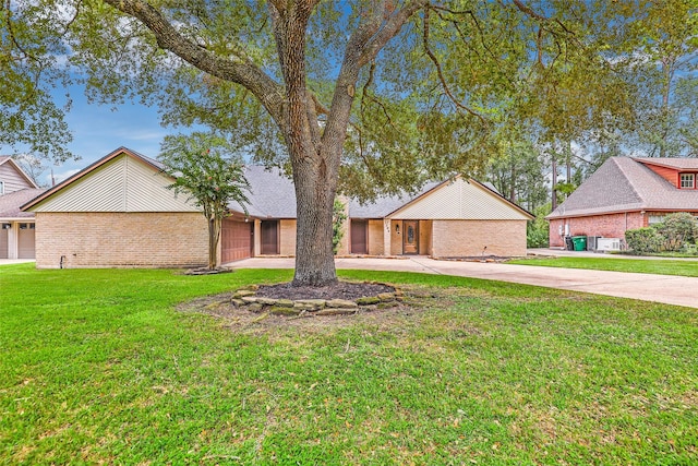 view of front facade with a garage, driveway, brick siding, and a front lawn