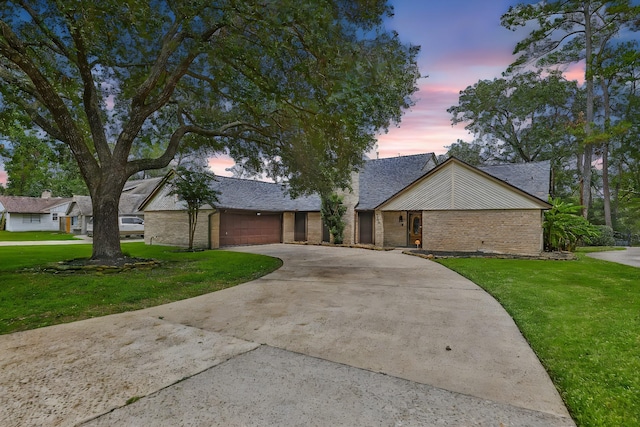 mid-century inspired home featuring an attached garage, brick siding, driveway, roof with shingles, and a front lawn