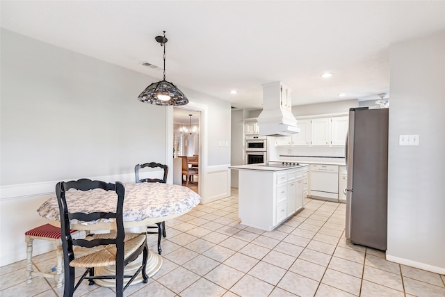 kitchen with custom range hood, visible vents, white cabinets, a kitchen island, and white appliances