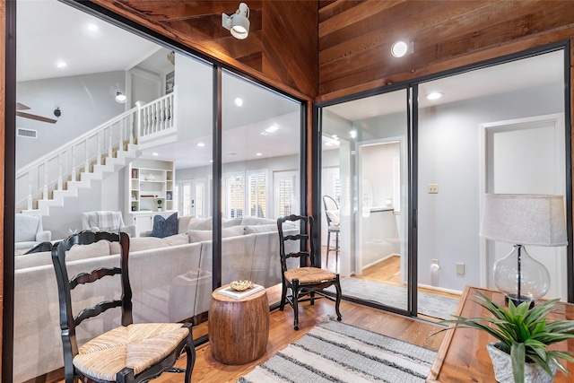 wine cellar featuring high vaulted ceiling, baseboards, visible vents, and wood finished floors