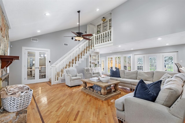 living room featuring stairs, visible vents, wood finished floors, and french doors