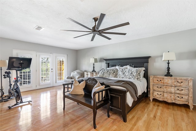 bedroom featuring access to exterior, visible vents, a ceiling fan, a textured ceiling, and light wood-type flooring