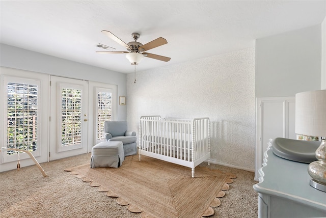 carpeted bedroom featuring ceiling fan, access to outside, visible vents, and wallpapered walls