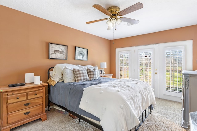 bedroom featuring access to exterior, light colored carpet, multiple windows, and ceiling fan