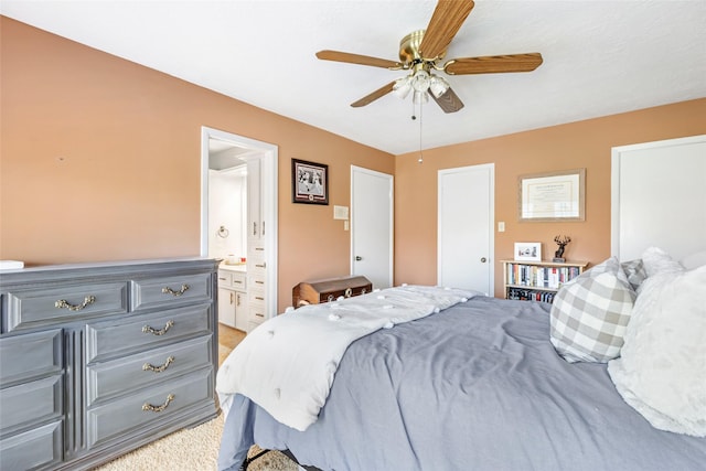 bedroom featuring light colored carpet, ceiling fan, and ensuite bathroom