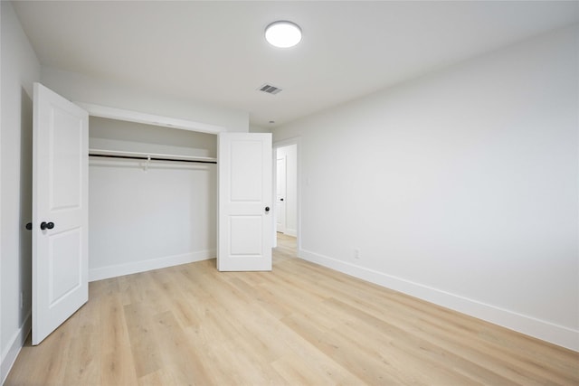 unfurnished bedroom featuring light hardwood / wood-style flooring and a closet