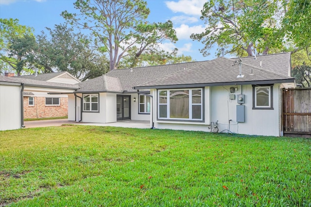 rear view of house featuring a lawn and a patio area