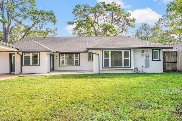 rear view of property featuring a yard and a patio area