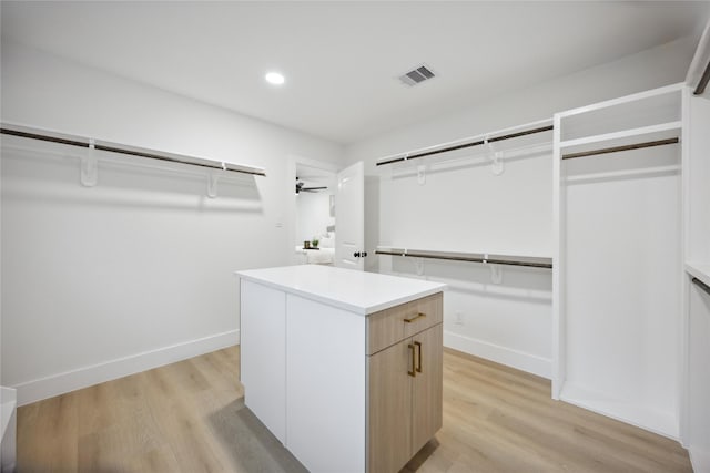 walk in closet featuring ceiling fan and light wood-type flooring