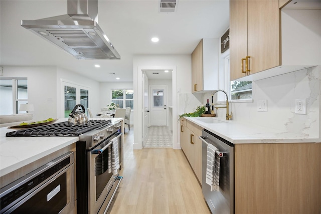 kitchen with sink, light stone counters, ventilation hood, backsplash, and appliances with stainless steel finishes