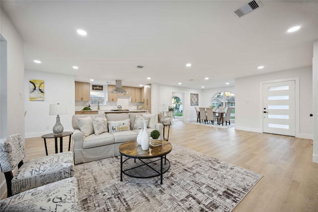 living room with a wealth of natural light and light hardwood / wood-style flooring