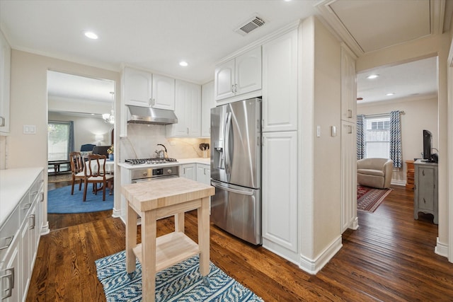 kitchen featuring white cabinets, appliances with stainless steel finishes, crown molding, and dark wood-type flooring