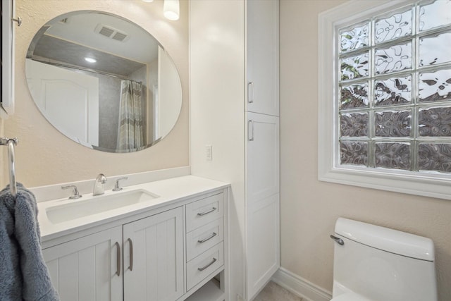 bathroom featuring vanity, curtained shower, and toilet