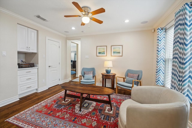 living area with ornamental molding, ceiling fan, and dark wood-type flooring