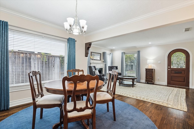 dining room with dark hardwood / wood-style flooring, crown molding, and a chandelier