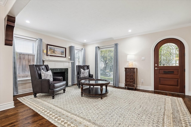 living area with crown molding, plenty of natural light, and dark hardwood / wood-style floors