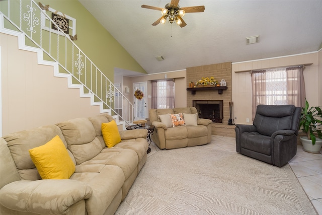 living room featuring ceiling fan, tile patterned flooring, high vaulted ceiling, and a brick fireplace