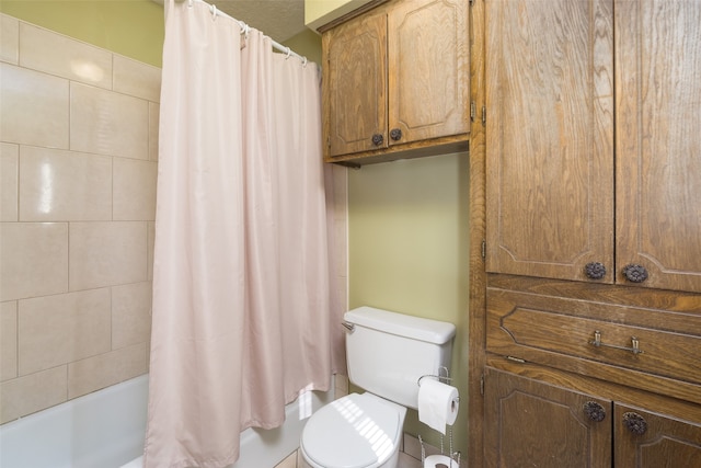 bathroom featuring shower / bath combination with curtain and toilet