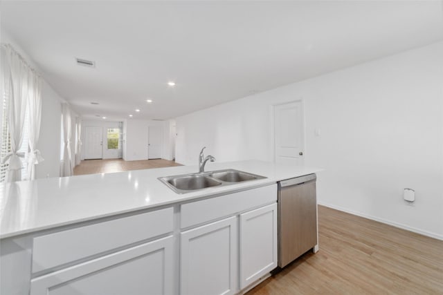 kitchen with stainless steel dishwasher, light hardwood / wood-style floors, white cabinets, and sink