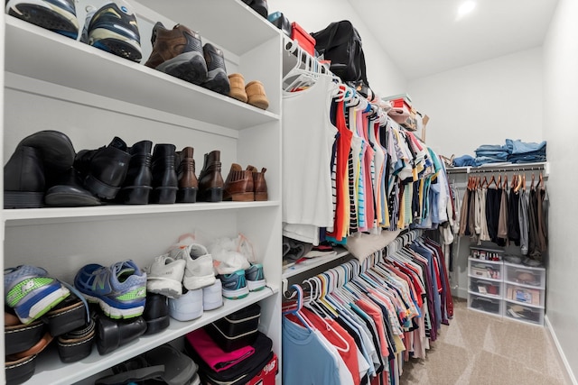 walk in closet with light colored carpet