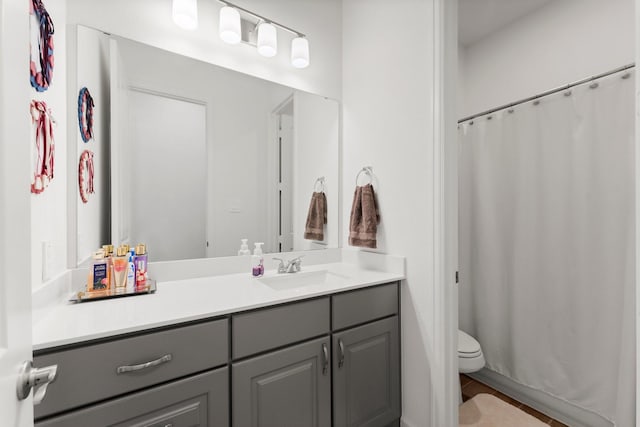 bathroom featuring vanity, toilet, and walk in shower