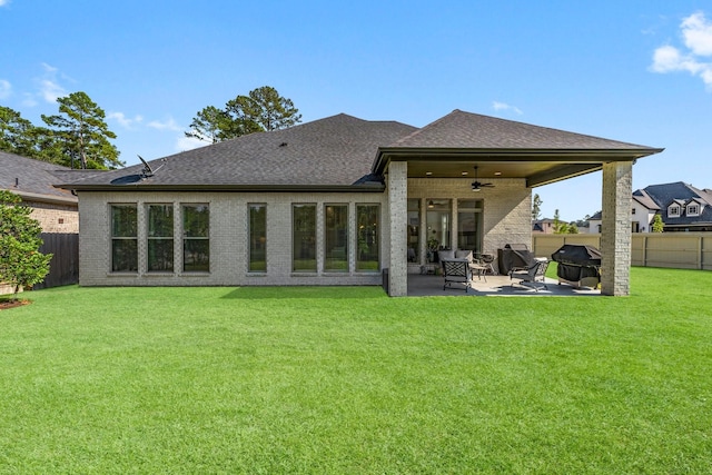 back of property with a patio, ceiling fan, and a lawn