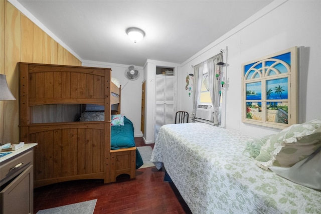 bedroom with cooling unit, dark hardwood / wood-style floors, and ornamental molding