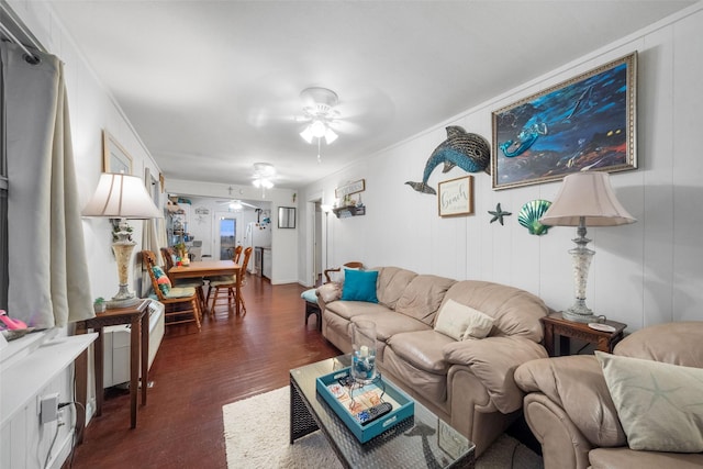 living room featuring crown molding, ceiling fan, and dark wood-type flooring