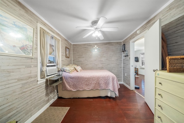 bedroom with ceiling fan, wooden walls, crown molding, cooling unit, and dark hardwood / wood-style floors