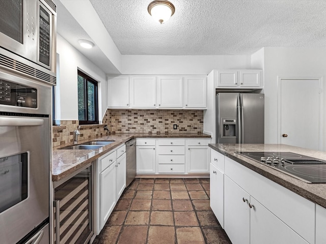 kitchen featuring backsplash, wine cooler, white cabinets, and stainless steel appliances