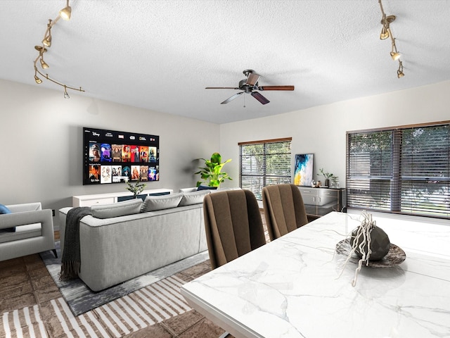 dining area featuring ceiling fan and a textured ceiling