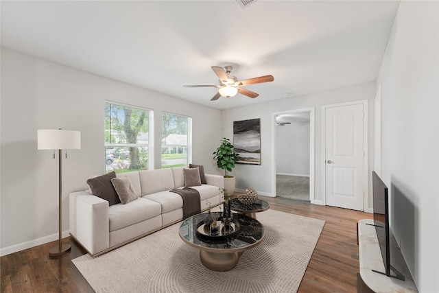 living room featuring ceiling fan and dark hardwood / wood-style floors