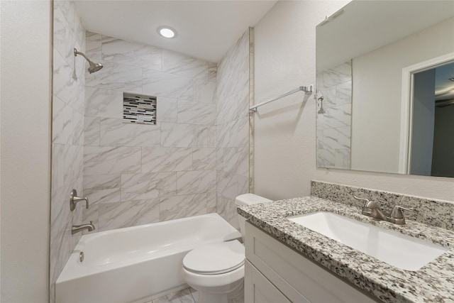 full bathroom with vanity, tiled shower / bath combo, and toilet