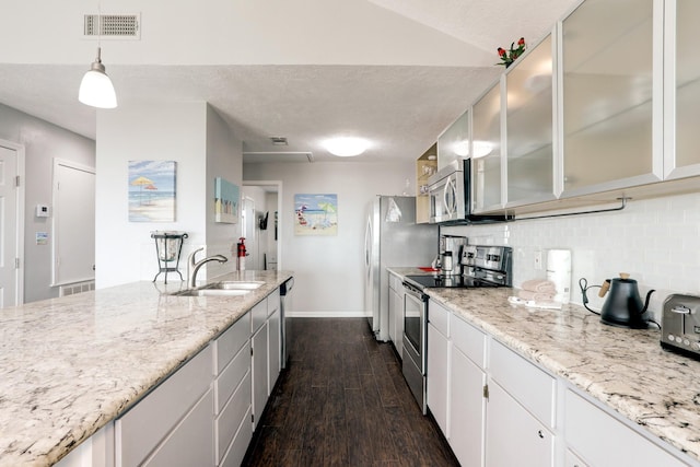 kitchen with dark wood-type flooring, white cabinets, sink, hanging light fixtures, and stainless steel appliances