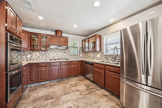 kitchen featuring backsplash, sink, ornamental molding, light stone counters, and stainless steel appliances